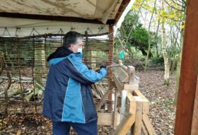 person working a green pole lathe