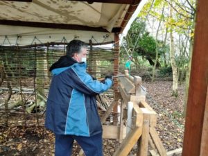 person working a green pole lathe